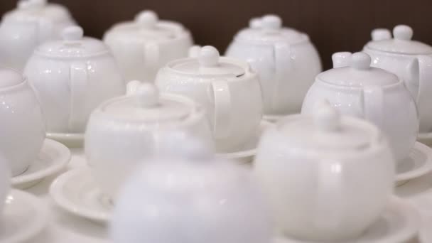 Weiße Teekannen auf einem Tisch — Stockvideo