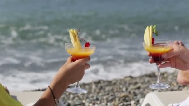 Paar geproost glazen cocktail op het strand voor de zee — Stockvideo