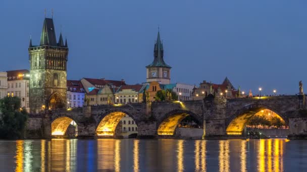 De Charles Bridge dag tot nacht timelapse over de rivier de Moldau gereflecteerd in water in Praag, Tsjechië — Stockvideo