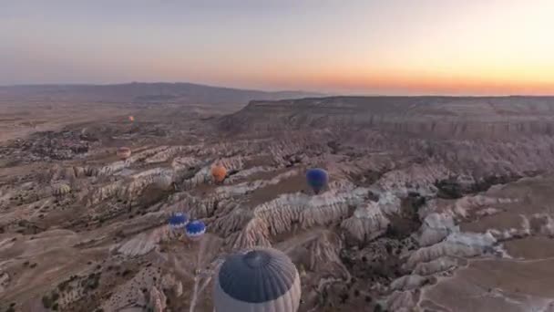 Güneş doğarken, Kapadokya 'nın peri masalı manzara tepelerinde, sıcak hava balonundan gelen hava manzarası sabah ışıklarıyla birlikte hızlanır.. — Stok video