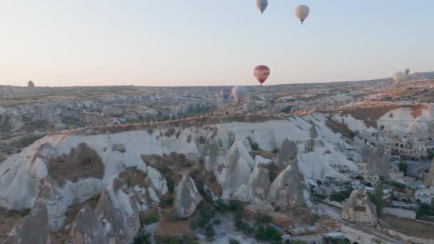 Vista aérea desde el globo aerostático durante el amanecer sobre las colinas del paisaje de cuento de hadas de Kapadokya con luz de la mañana. — Vídeos de Stock