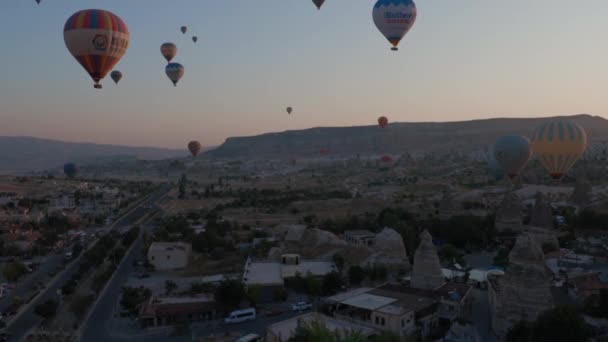 Légi felvétel hőlégballonból napkeltekor a Kapadokya mesebeli táj felett, reggeli fénnyel. — Stock videók