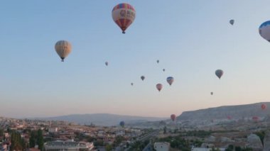 Güneş doğarken, Kapadokya 'nın peri masalı tepelerinde sabah güneşiyle birlikte sıcak hava balonundan hava manzarası..
