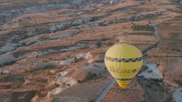 Vista aérea desde el globo aerostático durante el amanecer sobre las colinas del paisaje de cuento de hadas de Kapadokya con luz de la mañana. — Vídeos de Stock