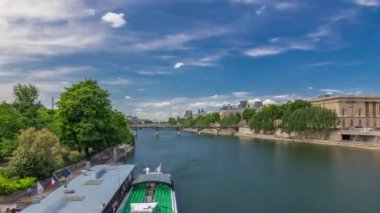 Turistik tekne Pont des Arts 'ın aşağısından geçiyor ve Paris' te Seine Nehri 'ndeki tekne istasyonunda duruyor..