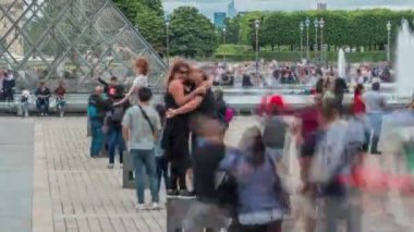 Turistler poz veriyor ve Louvre Müzesi yakınlarında fotoğraf çekiyorlar. Ünlü Fransız Müzesi. Paris, Fransa