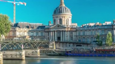 İnsanlar Fransa Enstitüsü ile Louvre zaman çizelgesi arasındaki Seine Nehri üzerindeki Sanat Köprüsü 'nde yürüyorlar.