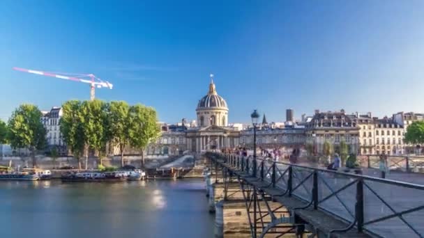 As pessoas caminham na Ponte das Artes sobre o Rio Sena até o hiperlapso temporal do Instituto da França - Paris, França — Vídeo de Stock