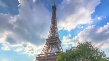 Eyfel Kulesi 'nde, gün batımında bulutların içinde sıcak ışık huzmeleri ve yüksek hız..