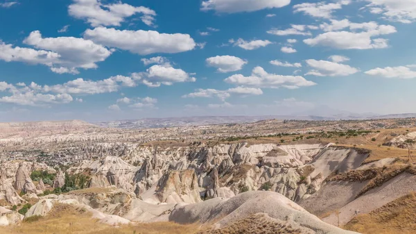Red Valley and Rose Valley of Goreme of Nevsehir in Cappadocia aerial timelapse, Turkey. Love valley and fairy chimneys panoramic view with clouds on a blue sky