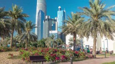 Abu Dabi 'deki sahil şeridi boyunca uzanan Corniche Bulvarı plajı parkında arka planda gökdelenler var..