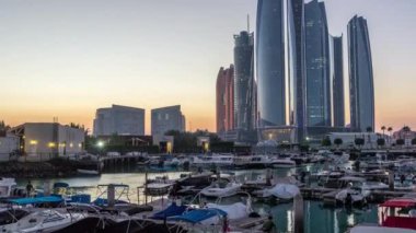 Al Bateen marinası Abu Dabi 'den gece saatine modern gökdelenler arka planda