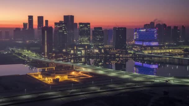 Skyline von Abu Dhabi mit Wolkenkratzern vor Sonnenaufgang von oben Nacht auf Tag Zeitraffer — Stockvideo
