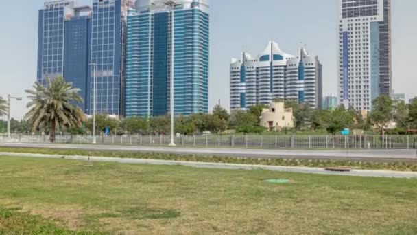 Corniche boulevard strandpark längs kusten i Abu Dhabi timelapse med skyskrapor på bakgrunden. — Stockvideo