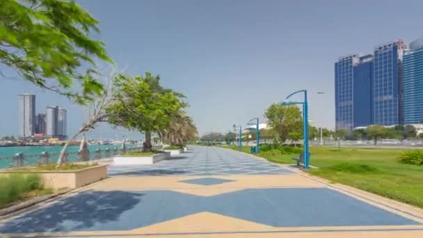 Corniche boulevard beach park mentén partvonal Abu Dhabi timelapse hyperlapse felhőkarcolók a háttérben. — Stock videók