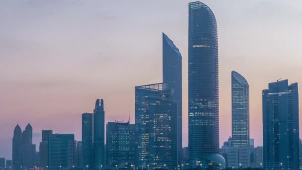 Abu Dhabi stad skyline met wolkenkrabbers voor zonsopgang met water reflectie nacht tot dag timelapse — Stockvideo
