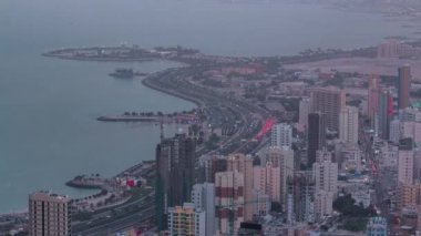 Kuveyt 'te gece gündüz gökdelenlerle gökyüzü çizgisi alacakaranlıkta aydınlandı. Kuveyt Şehri, Orta Doğu