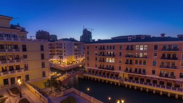 Vista aérea del canal en el barrio de Qanat, similar a Venecia, en el distrito Pearl de Doha, de día a noche, Qatar. — Vídeo de stock