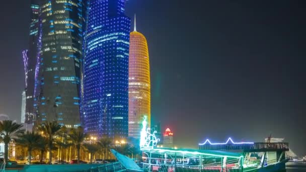 Hagyományos dhow csónak Dohában éjszaka, modern épületekkel a háttérben. — Stock videók