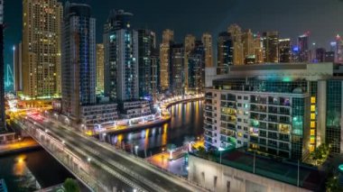 Dubai Marina, gece saatlerinde. Suda ve araçlarda hafif tekne izleri var. Dubai, BAE.