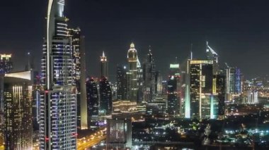 Gece Dubai şehir merkezindeki gökyüzü zaman çizelgesi. Şeyh Zayed yolunun çatısı. Çok sayıda aydınlatma kulesi var..