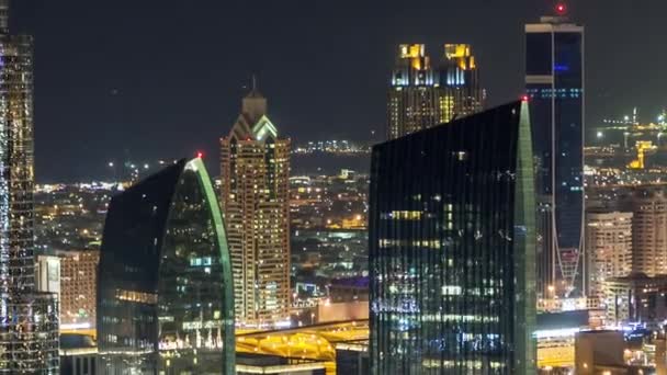 Dubais Skyline im Zeitraffer in der Nacht. Dachterrasse der Sheikh Zayed Road mit zahlreichen beleuchteten Türmen. — Stockvideo