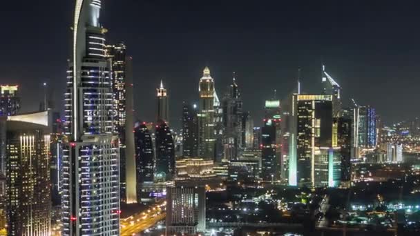 Dubais Skyline im Zeitraffer in der Nacht. Dachterrasse der Sheikh Zayed Road mit zahlreichen beleuchteten Türmen. — Stockvideo