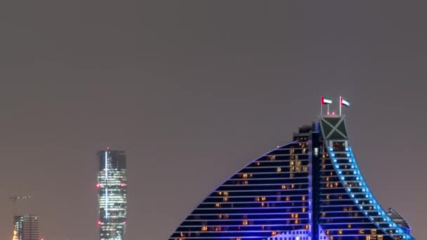 Skyline of Dubai в ночное время с Burj al Arab на переднем плане в Дубае, ОАЭ — стоковое видео