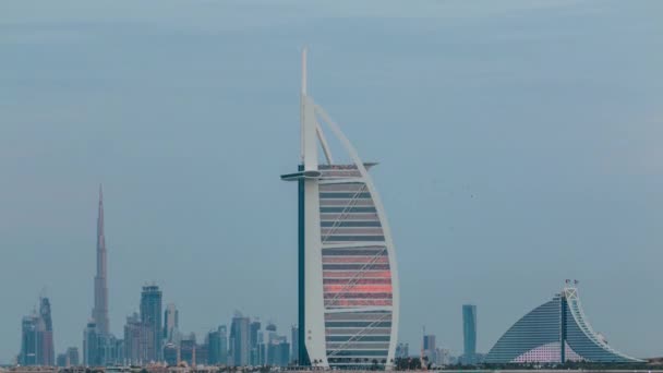 Ντουμπάι ορίζοντα με Burj Al Arab ξενοδοχείο κατά τη διάρκεια του ηλιοβασιλέματος και της ημέρας με τη νύχτα timelapse. — Αρχείο Βίντεο