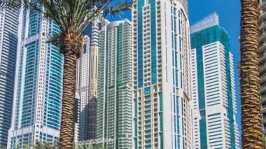 Gün içinde Marina Yürüyüşü 'nde fıskiyeler ve palmiyeler zaman ayarlı. Dubai, BAE