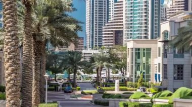 Gün içinde Marina Yürüyüşü 'nde fıskiyeler ve palmiyeler zaman ayarlı. Dubai, BAE