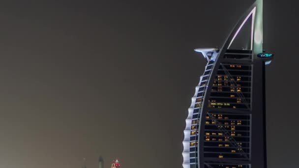 Dubai skyline with Burj Al Arab hotel at night timelapse. — Stock Video