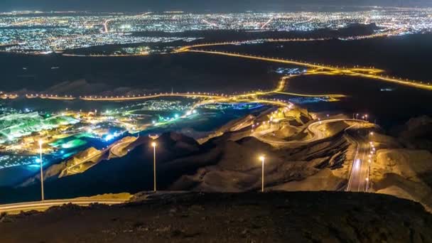 Timelapse nocturne avec des rochers de Jebel Hafeetavec une vue impressionnante sur la ville. — Video