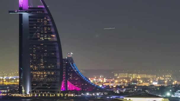 Dubai skyline with villas and Burj Al Arab night timelapse. — Stock Video