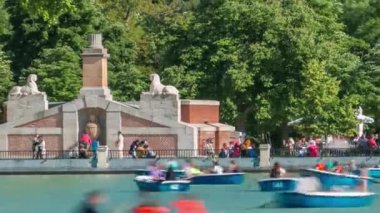 Tourists on boats at lake near Monument to Alfonso XII timelapse in the Park of the Pleasant Retreat in Madrid, Spain