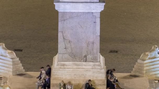 사람들은 밤 시간 대에 피아자델 포폴로 광장의 중앙 기둥 아래모여 있다 — 비디오
