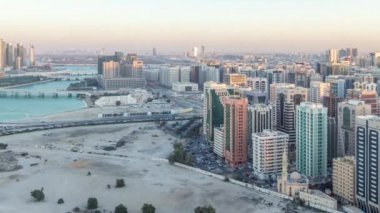Abu Dabi şehir merkezinin havadan ufuk çizgisi, günden geceye zaman çizelgesi.