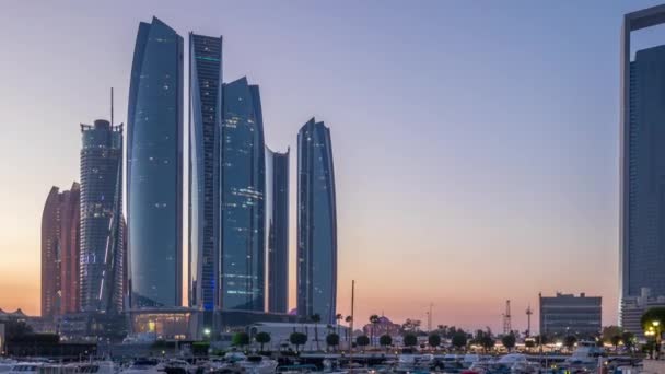 Al Bateen marina Abu Dhabi dzień do nocy timelapse z nowoczesnymi drapaczami chmur na tle — Wideo stockowe