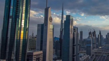 Dubai gökdelenleri, gün batımı akşam vakti. Dubai Metro İstasyonu ve Şeyh Zayed Yolu üzerindeki trafik