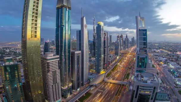 Dubai arquitectura céntrica día a noche timelapse. Vista superior de la carretera Sheikh Zayed con rascacielos iluminados y tráfico. — Vídeos de Stock