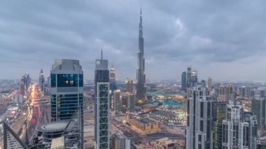 Dubai 'nin panoramik ufuk çizgisi günden geceye zaman çizelgesi, Birleşik Arap Emirlikleri. Dünyaca ünlü gökdelenlerin manzarası.