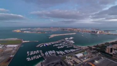Jumeirah Palm Island 'da gece gündüz Dubai' de Dubai marinasının çatısından çekiliyor.