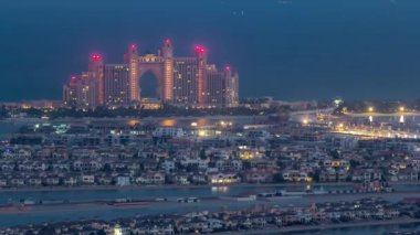 Jumeirah Palm Island 'da gece gündüz Dubai' de Dubai marinasının çatısından çekiliyor.