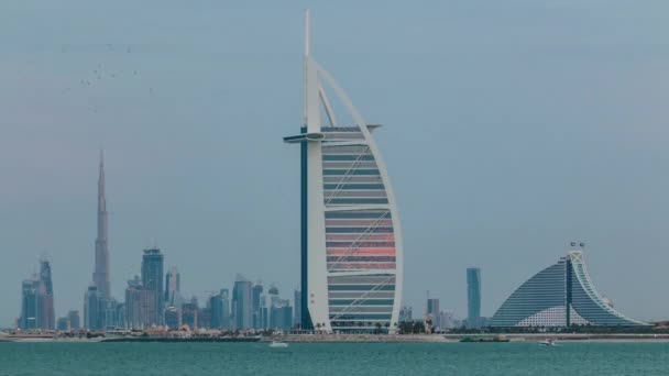 Dubai skyline with Burj Al Arab hotel during sunset and day to night timelapse. — Stock Video