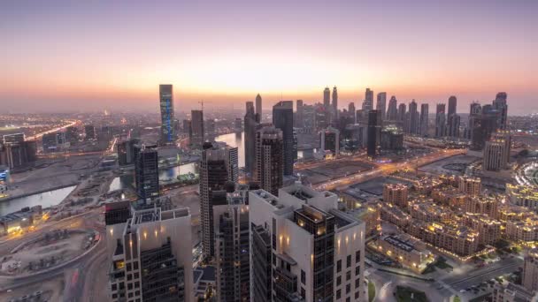 Büyük, modern bir şehrin havadan görünüşü. Gündüzden geceye. İş Körfezi, Dubai, Birleşik Arap Emirlikleri. — Stok video
