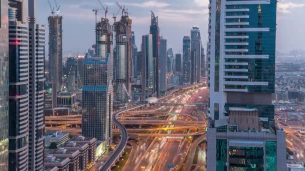 Архітектура Дубай в центрі міста від дня до ночі. Верхній вид через Шейх Заїд дорогу з освітленими хмарочосами і трафіком. — стокове відео