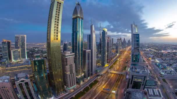 Dubai arquitectura céntrica día a noche timelapse. Vista superior de la carretera Sheikh Zayed con rascacielos iluminados y tráfico. — Vídeo de stock