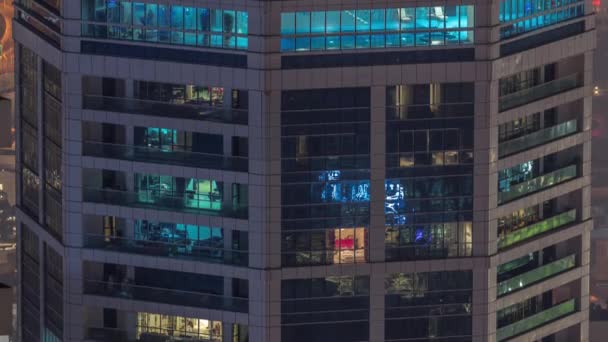 Ventanas en el exterior del edificio de gran altura al final de la noche con luces interiores en timelapse — Vídeo de stock