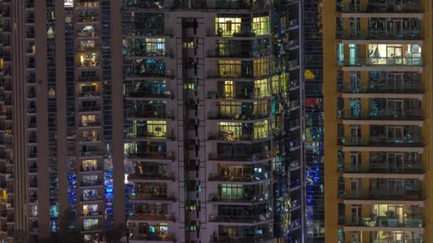 Ventanas en el exterior del edificio de gran altura al final de la noche con luces interiores en timelapse — Vídeo de stock