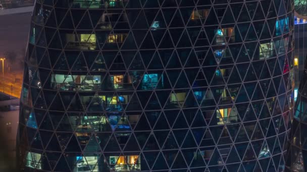 Ventanas en el exterior del edificio de gran altura al final de la noche con luces interiores en timelapse — Vídeo de stock